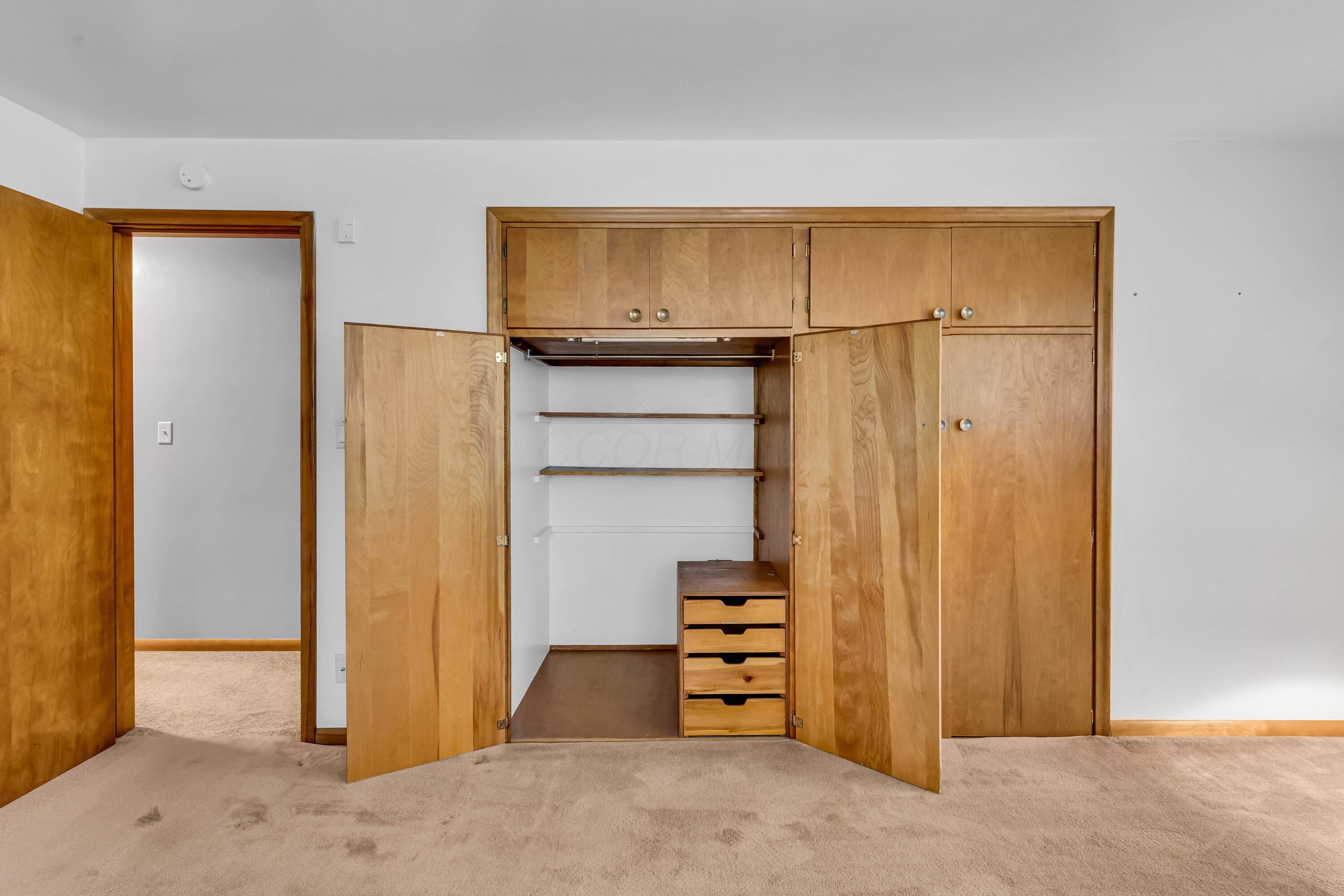 1213 East Cooke Road Columbus, OH 43224 - Photo 36 of 57 • Tan carpet • Hardwood flooring under carpet • Tan painted walls • Lighted ceiling fan • Deep, lighted closet • Built-in desk/vanity