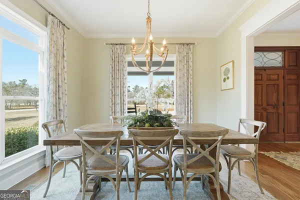 a dining room with furniture a chandelier and wooden floor