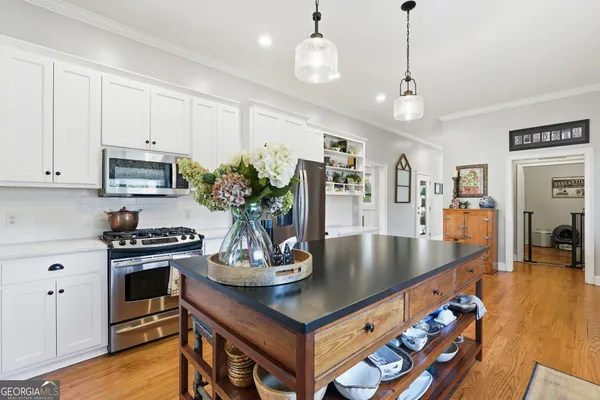 a kitchen with stainless steel appliances granite countertop a lot of counter space and wooden floor