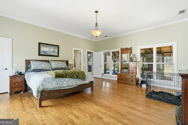 a spacious bedroom with a bed a couch and large window