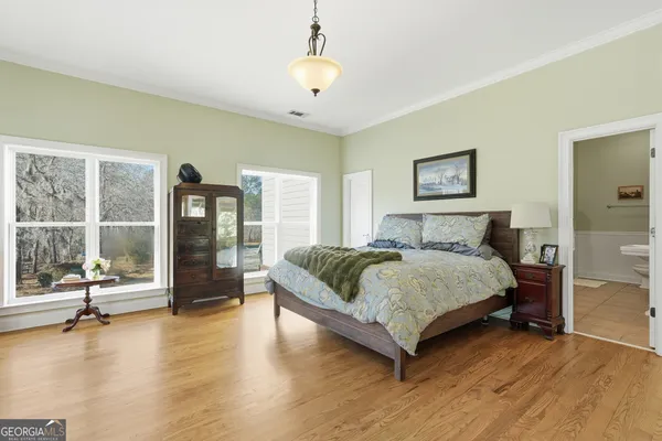a bedroom with a large bed and a chandelier