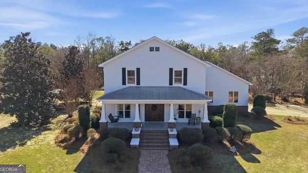 a front view of house with yard and trees in the background