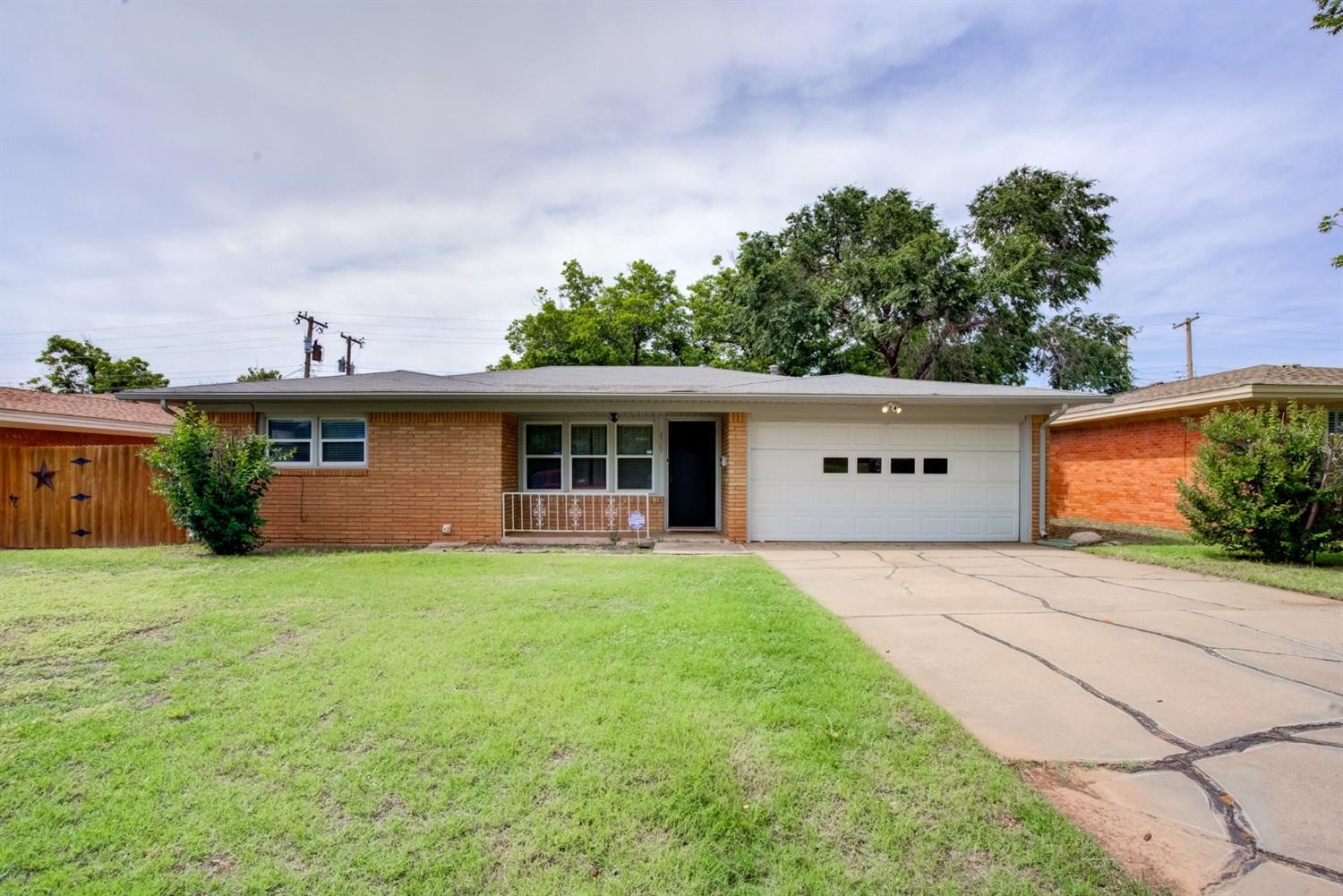 a front view of house with yard and trees in the background