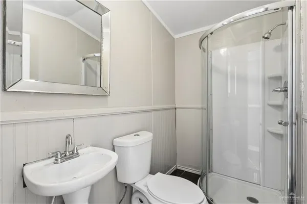 a bathroom with a toilet a sink a mirror and shower