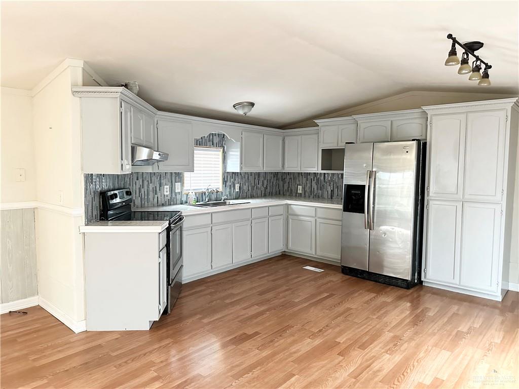 2408 Verbena Avenue Edinburg, TX 78542 - Photo 3 of 19 a kitchen with white cabinets a sink a window and stainless steel appliances