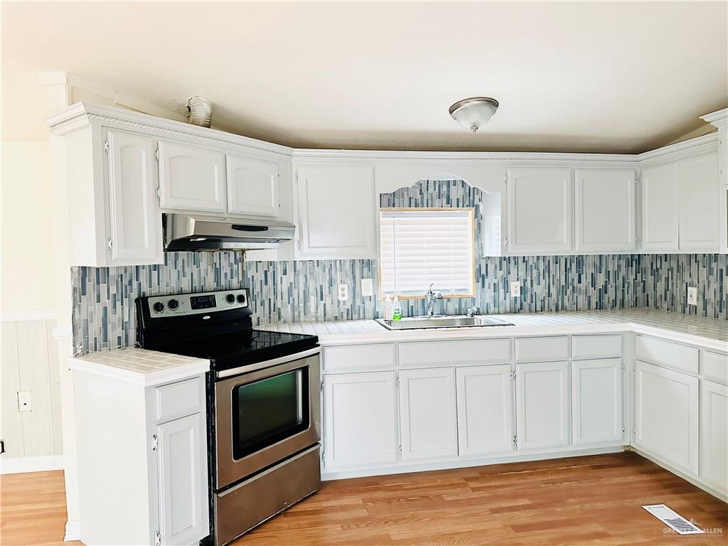 2408 Verbena Avenue Edinburg, TX 78542 - Photo 8 of 19 a kitchen with granite countertop white cabinets and white appliances