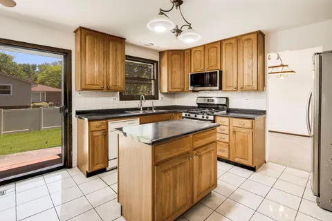 a kitchen with granite countertop a sink appliances and cabinets