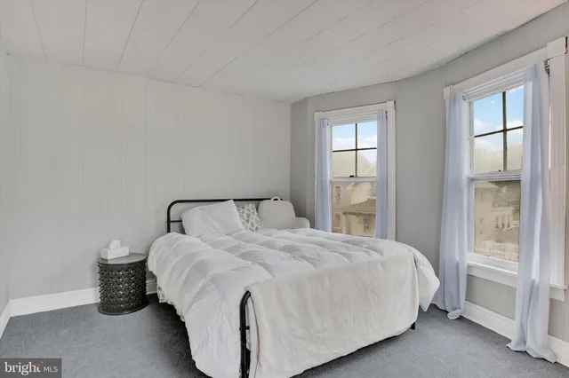 a large bed sitting in a bedroom next to a window