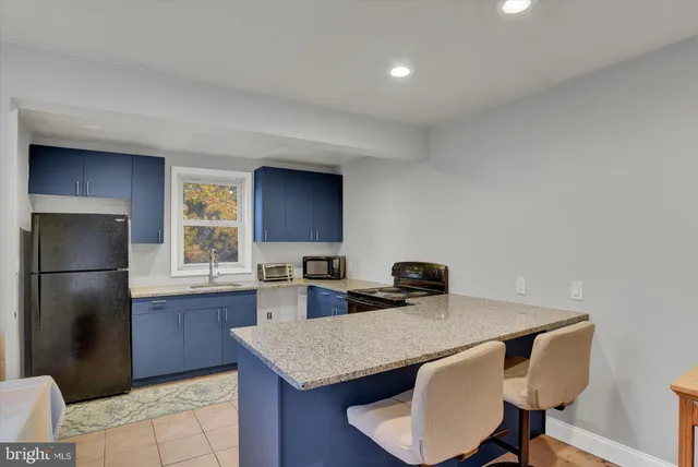 a kitchen with a refrigerator a sink dishwasher a stove and a refrigerator with wooden floor