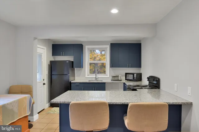 a kitchen with stainless steel appliances granite countertop a sink a stove and a refrigerator