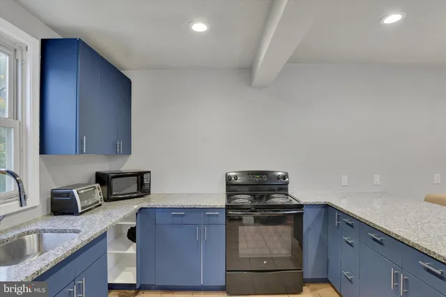a kitchen with granite countertop a stove and a sink