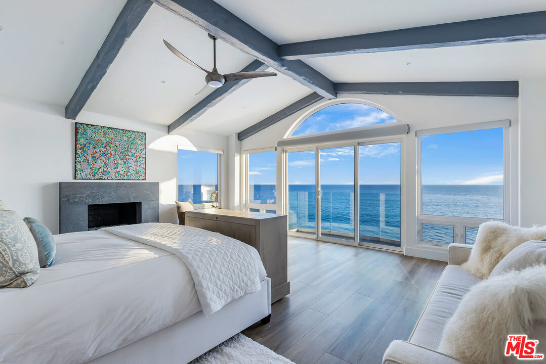 27336 Escondido Beach Road Malibu, CA 90265 - Photo 12 of 23 a large bedroom with wooden floor and a fireplace