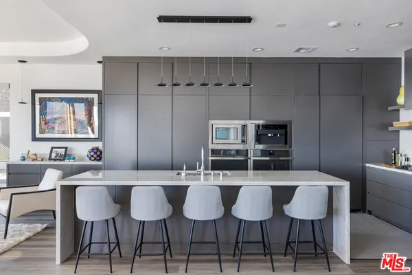 a kitchen with a dining table chairs and white cabinets