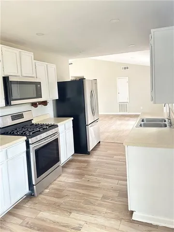 a kitchen with granite countertop a refrigerator stove and microwave