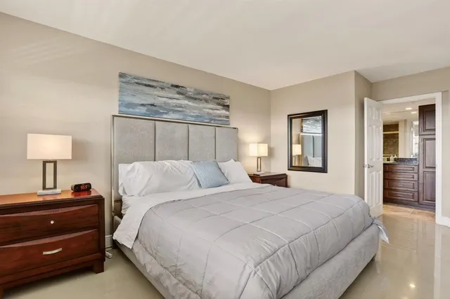 a bedroom with a bed and a lamp on dresser