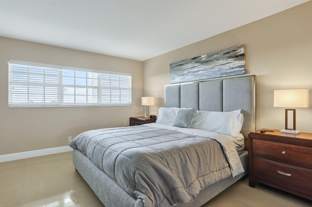 605 Oaks Drive, Unit 1008 Pompano Beach, FL 33069 - Photo 19 of 30 a bedroom with a bed and a lamp