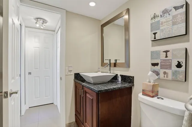 a bathroom with a granite countertop sink and a mirror
