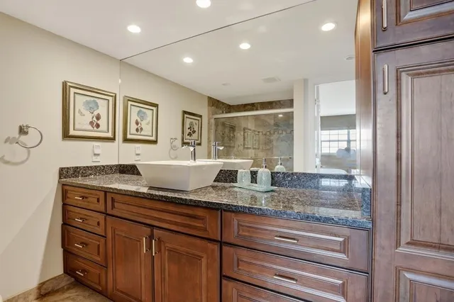a bathroom with a granite countertop sink a mirror and a window