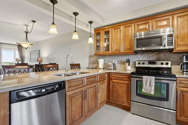 a kitchen with stainless steel appliances granite countertop a stove a sink and a microwave