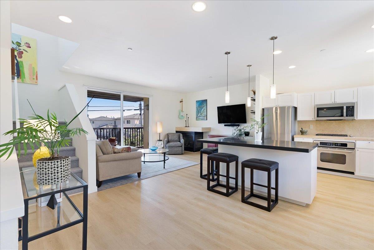 117 Gault Street, Unit B Santa Cruz, CA 95062 - Photo 6 of 42 a living room with stainless steel appliances a kitchen island hardwood floor and a television
