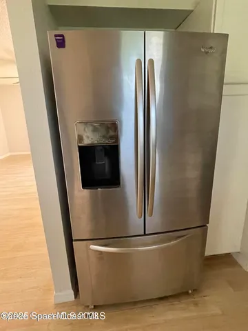 a picture of a white wall with a bench and a table in it