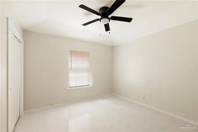 an empty room with a window and a fan