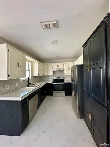 a kitchen with stainless steel appliances granite countertop a refrigerator and a sink