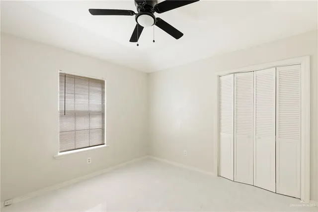 an empty room with closet and windows