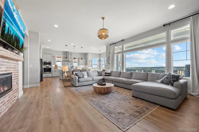a living room with furniture kitchen view and a large window