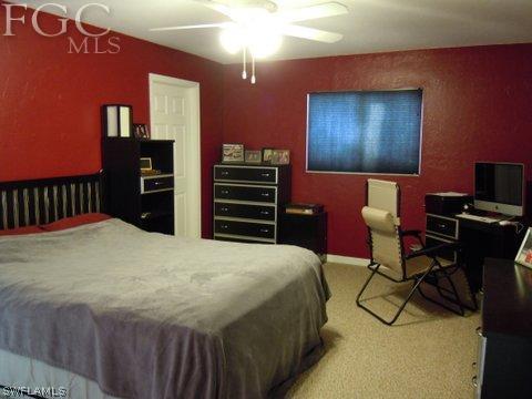 17552 Ingram Road Fort Myers, FL 33967 - Photo 4 of 5 a bedroom with a bed and a chandelier