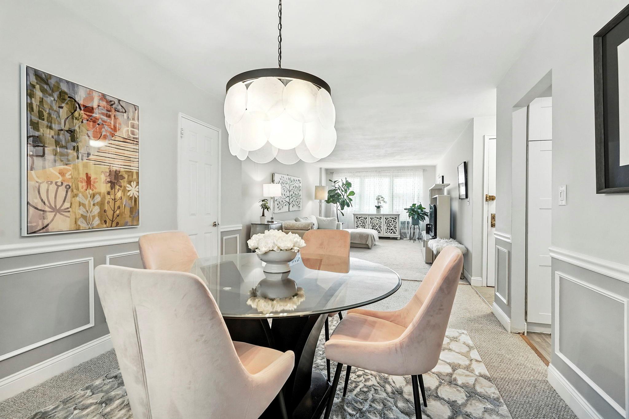 1 Avon Circle, Unit D Rye Brook, NY 10573 - Photo 1 of 1 Elegant dining area featuring a modern glass panel chandelier, seamlessly flowing into the spacious living room—perfect for entertaining and everyday living.
