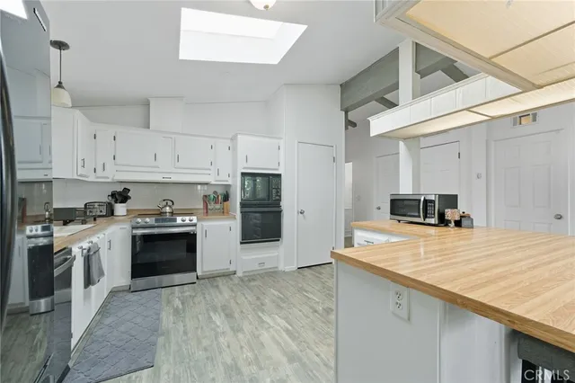 a view of kitchen with refrigerator and wooden floor