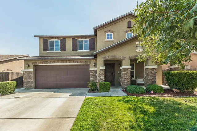 a front view of a house with a yard and garage
