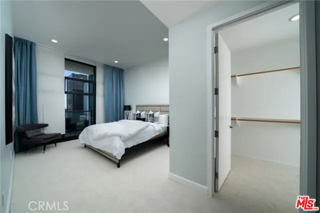 a large bedroom with a bed and glass wall
