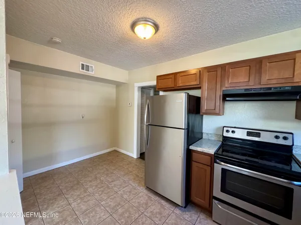 a kitchen with a refrigerator and a stove