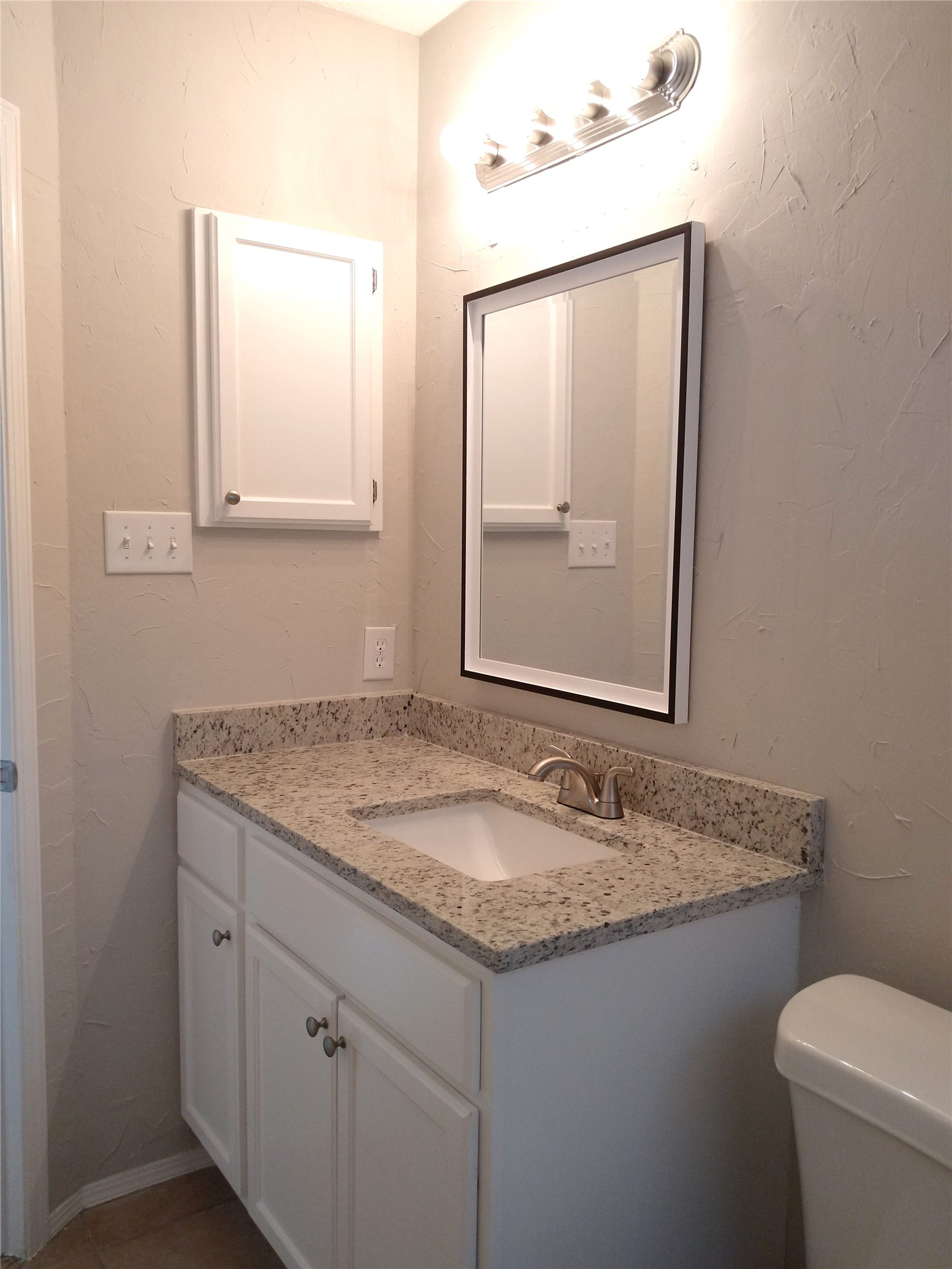 1813 Laurel Path Round Rock, TX 78664 - Photo 19 of 35 A well-appointed bathroom features a single vanity with stone counters and a framed mirror.