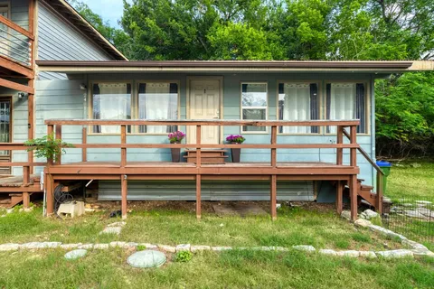 a view of a wooden bench sitting in front of house
