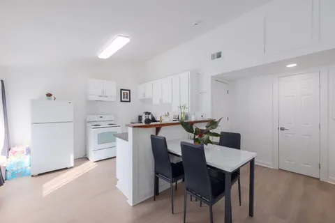 a view of kitchen with refrigerator dining table and chairs