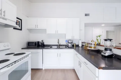 a kitchen with stainless steel appliances a sink a stove and cabinets