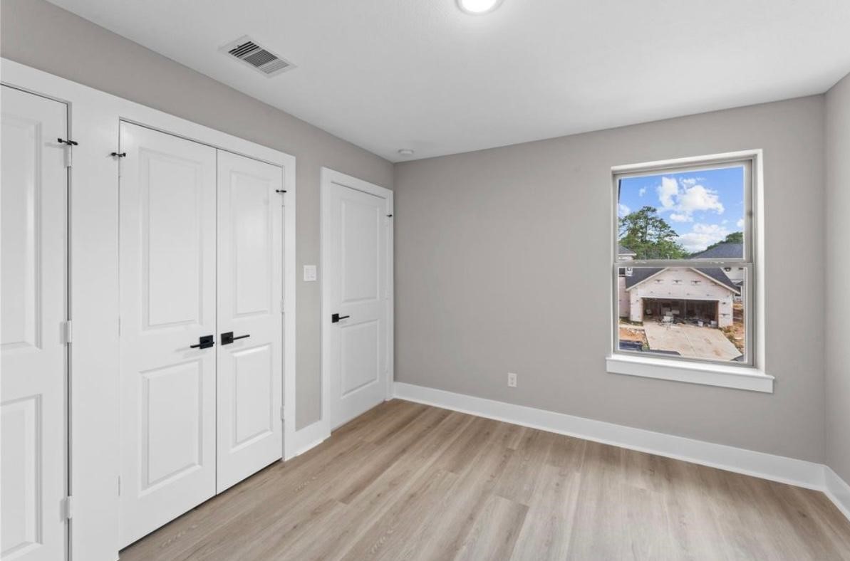 2606 Liguria Ln Spring Spring, TX 77388 - Photo 21 of 29 a view of an empty room with wooden floor and a window