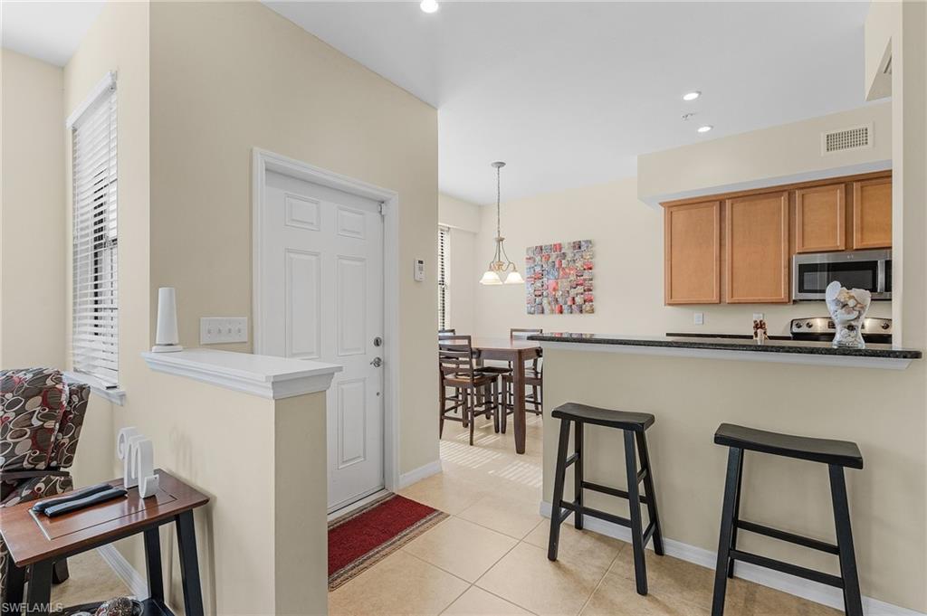 3732 Pino Vista Way, Unit 2 Estero, FL 33928 - Photo 4 of 29 a kitchen with stainless steel appliances granite countertop white cabinets a table and chairs