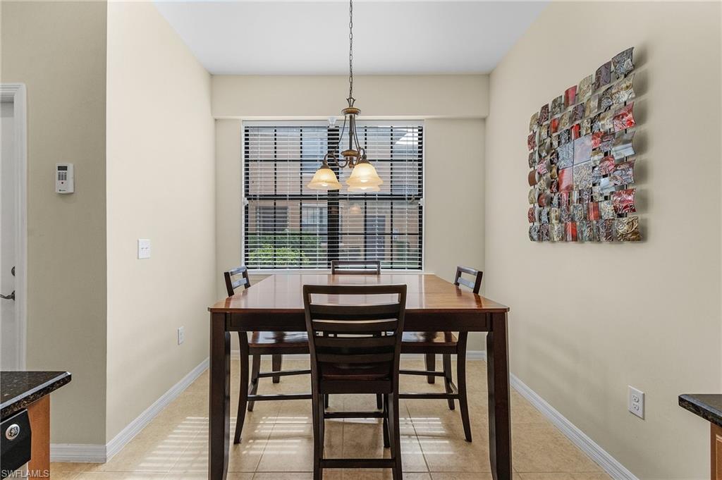 3732 Pino Vista Way, Unit 2 Estero, FL 33928 - Photo 5 of 29 a view of a dining room with furniture wooden floor and chandelier