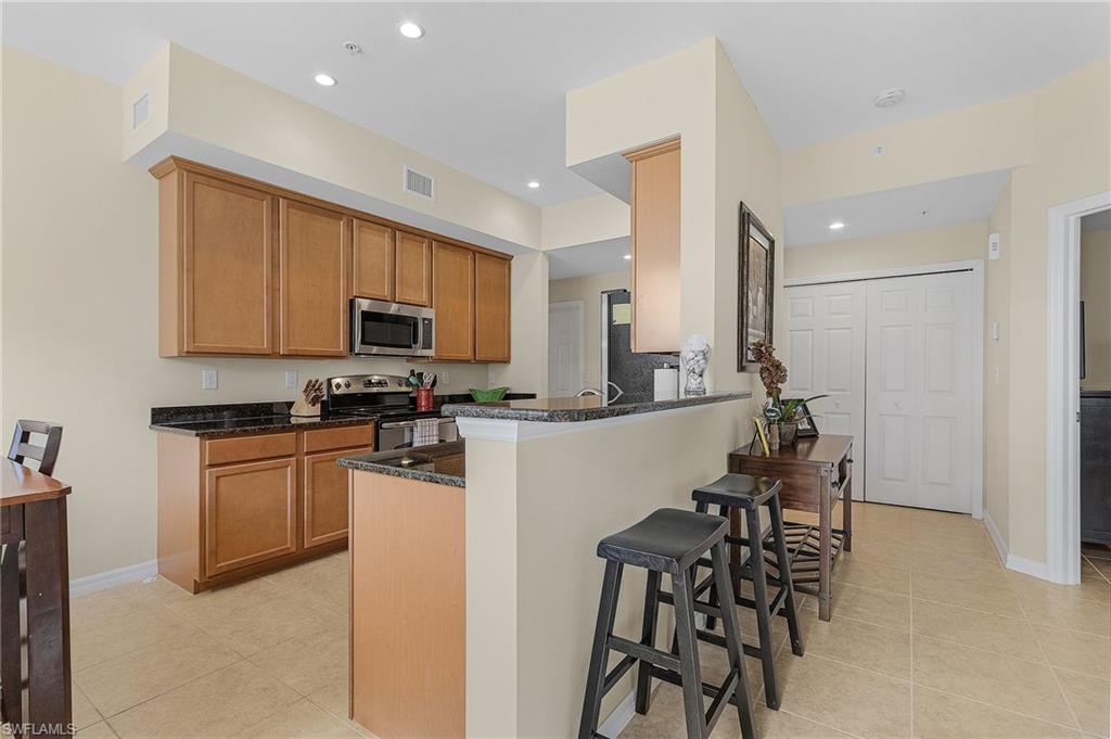 3732 Pino Vista Way, Unit 2 Estero, FL 33928 - Photo 6 of 29 a kitchen with white cabinets and stainless steel appliances