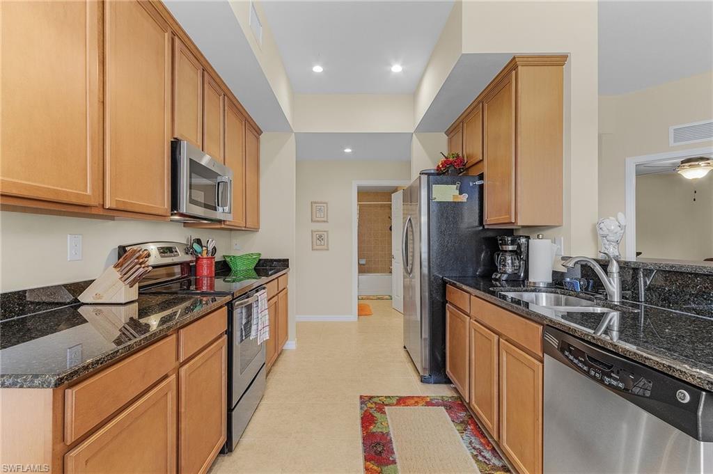 3732 Pino Vista Way, Unit 2 Estero, FL 33928 - Photo 8 of 29 a kitchen with stainless steel appliances granite countertop a sink stove and refrigerator