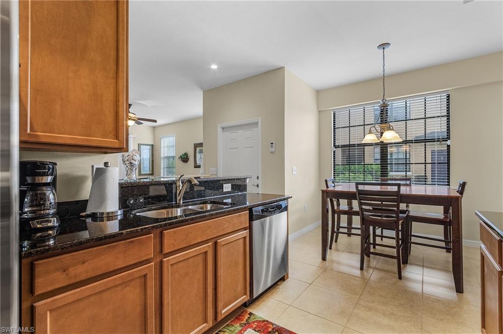 3732 Pino Vista Way, Unit 2 Estero, FL 33928 - Photo 9 of 29 a kitchen with counter top space cabinets dining table and stainless steel appliances