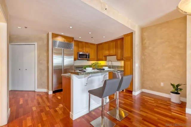 a kitchen with stainless steel appliances granite countertop a refrigerator and a stove top oven