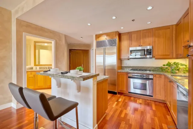 a kitchen with stainless steel appliances granite countertop a stove a sink and a microwave