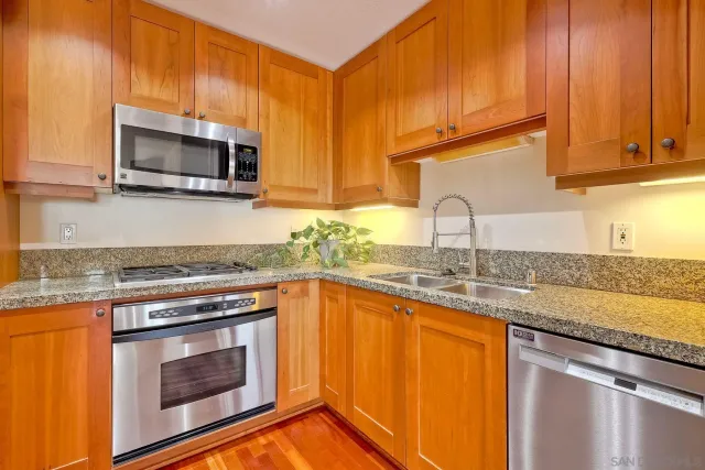 a kitchen with granite countertop a stove top oven microwave and cabinets