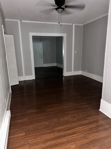 a view of a hallway with wooden floor and staircase