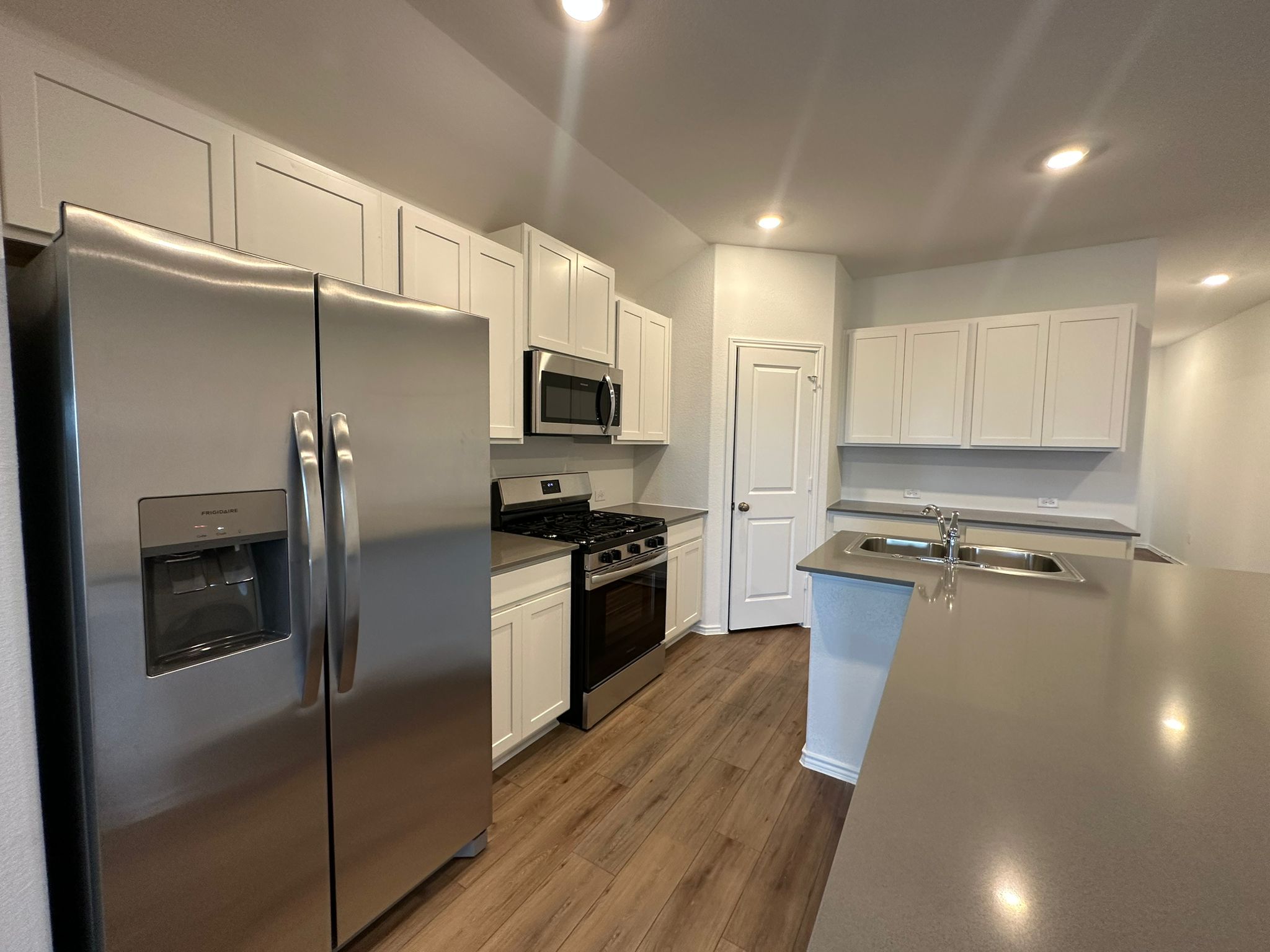 1594 Marley Kyle, TX 78640 - Photo 17 of 34 a kitchen with stainless steel appliances a refrigerator a stove a sink and white cabinets